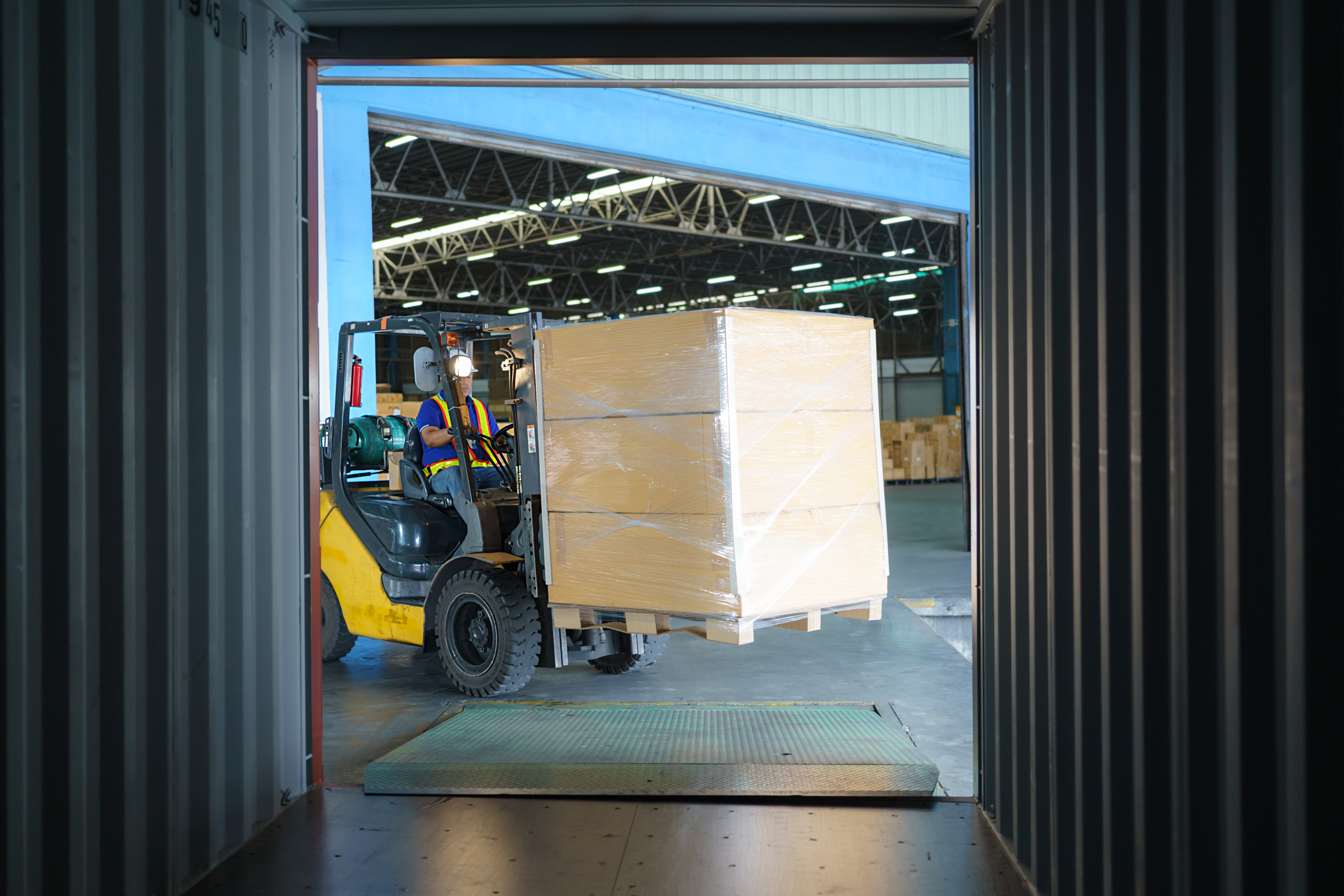 An image of an outsourced warehouse worker unloading a tractor-trailer is how to make a warehouse more efficient through outsourcing.